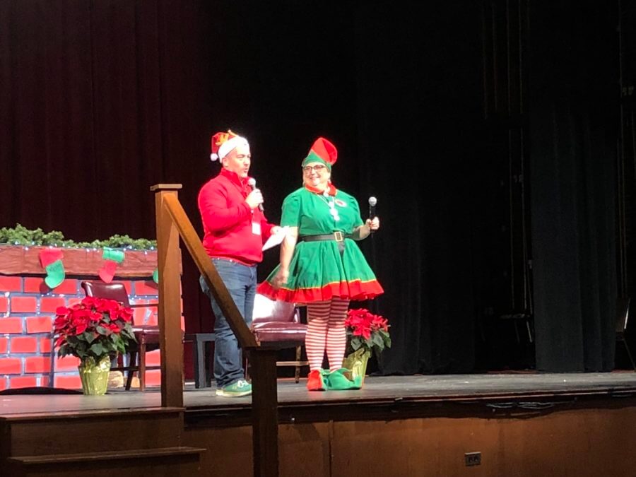 2 hosts wearing Santa outfit onstage