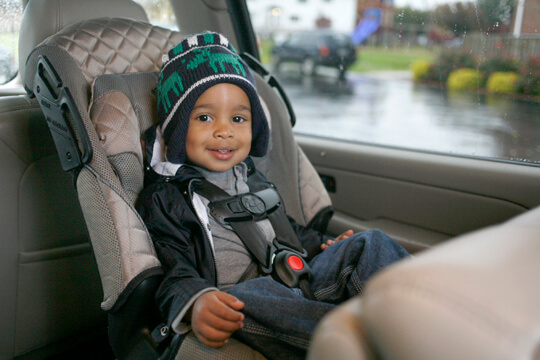 Smiling young boy on a car seat